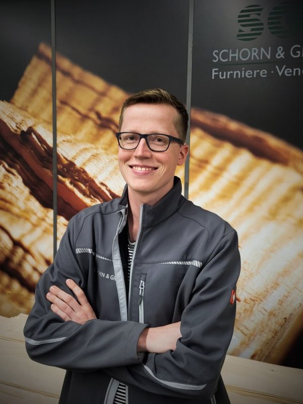 Leo_Weyherter__Young_Professional_bei_Schorn___Groh__laechelt_vor_einer_Kulisse_aus_Holzfurnieren